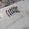 seven construction workers standing on white field